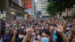 Protesters against the new national security law gesture with five fingers, signifying the "Five demands - not one less" on the anniversary of Hong Kong's handover to China from Britain in Hong Kong, Wednesday, July. 1, 2020. (AP Photo/Vincent Yu)