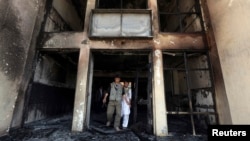 Afghan men walk out of Panjshir government building after an insurgent attack in Panjshir province, Afghanistan, May 29, 2013.