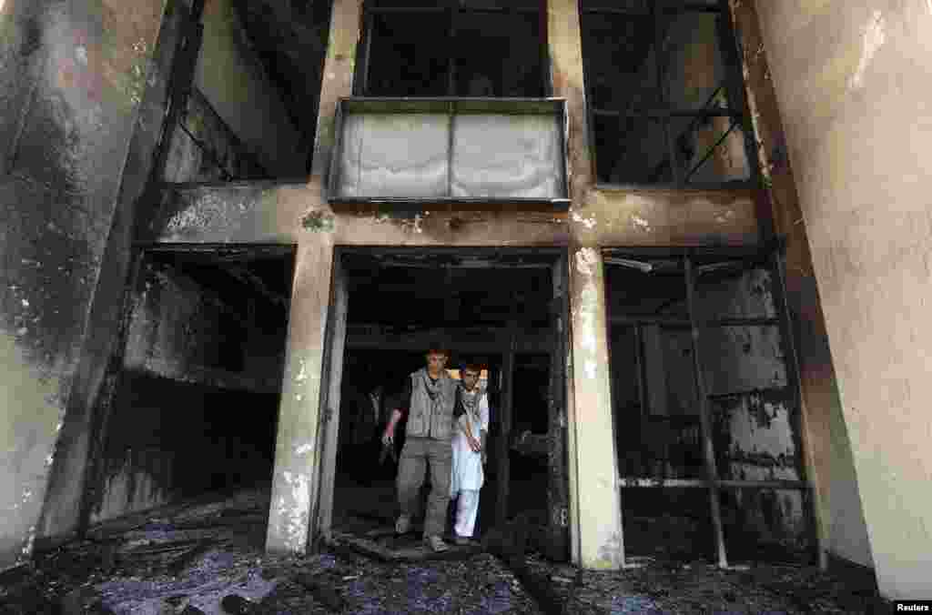 Afghan men walk out of Panjshir government building after an insurgent attack in Panjshir, Afghanistan, May 29, 2013.