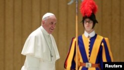 FILE - Pope Francis arrives to lead a special audience for members of Caritas association in Paul VI Audience Hall at the Vatican, April 21, 2016.