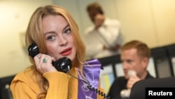 FILE - U.S. actress Lindsay Lohan speaks on a telephone during a charity day at BGC Partners in the Canary Wharf business district in London, Britain September 12, 2016. (REUTERS/Toby Melville)