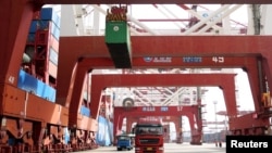 Trucks transport containers at a port in Qingdao, Shandong province, China, Apr. 8, 2018.