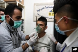 This photo released by the Syrian official news agency SANA shows a man receiving oxygen through respirators following a suspected chemical attack on his town of al-Khalidiya, in Aleppo, Syria, Nov. 24, 2018.