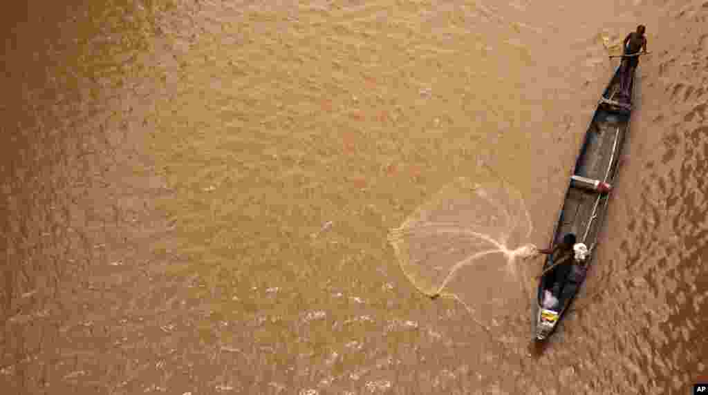 A fisherman casts his net into the River Mahanadi on the outskirts of Bhubaneswar, India.