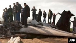 Libyans inspect the wreckage of a US F15 fighter jet after it crashed in an open field in the village of Bu Mariem, east of Benghazi, eastern Libya, March 22, 2011