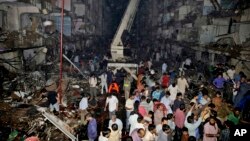 Medics and civilians gather at the site of a bomb blast in Karachi, Pakistan, March 3, 2013.