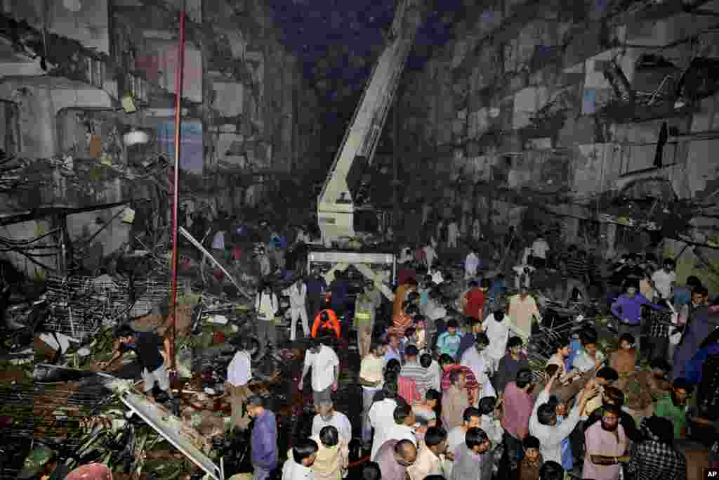 医务人员和平民2013年3月3日聚集在巴基斯坦卡拉奇一枚炸弹爆炸的现场。