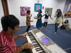 Sejumlah tenaga kerja wanita (TKW) asal Indonesia sedang berlatih menyanyi di Sekolah Indonesia Singapura saat hari libur, 12 Desember 2020. (Foto: Reuters)