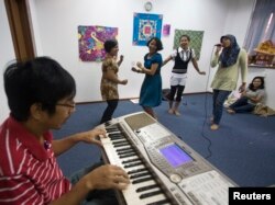 Sejumlah tenaga kerja wanita (TKW) asal Indonesia sedang berlatih menyanyi di Sekolah Indonesia Singapura saat hari libur, 12 Desember 2020. (Foto: Reuters)