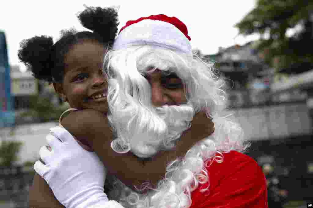 Leonan Pereira da Silva plays the part of Black Santa during a food donation event for the residents of the Vila Cruzeiro favela in Rio de Janeiro, Brazil.