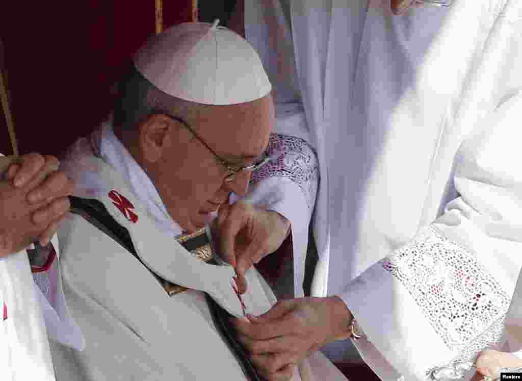 The pallium is fitted on Pope Francis during his inaugural mass in Saint Peter's Square at the Vatican, Mar. 19, 2013. 