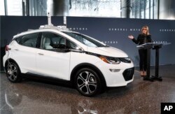 FILE - In this Thursday, Dec. 15, 2016, file photo, General Motors Chairman and CEO Mary Barra speaks next to a autonomous Chevrolet Bolt electric car, in Detroit.