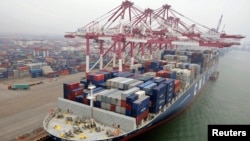 A cargo ship loaded with containers is seen anchored at a port in Qingdao, Shandong province, China, July 10, 2013.