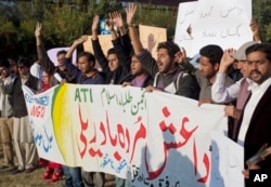 FILE _ Pakistani students shout slogans against the Islamic State group holding a banner that reads "down with Islamic State rally," in Islamabad, Nov. 20, 2014.