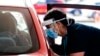 A health worker administers vaccinations at a pop-up drive-in clinic, in Auckland, New Zealand, Oct. 11, 2021. 