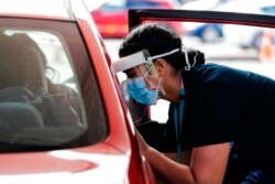 A health worker administers vaccinations at a pop-up drive-in clinic, in Auckland, New Zealand, Oct. 11, 2021.