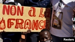Demonstrators hold a placard that reads "No to France" during a protest calling for the departure of French forces from Burkina Faso, in the capital Ouagadougou, Nov. 16, 2021.