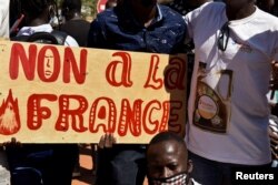 ARCHIVES - Des manifestants tiennent une pancarte sur laquelle on peut lire "Non à la France" lors d'une manifestation demandant le départ des forces françaises du Burkina Faso, dans la capitale Ouagadougou, le 16 novembre 2021.