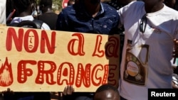 FILE - Demonstrators hold a placard that reads "No to France" during a protest calling for the departure of French forces from Burkina Faso, in the capital Ouagadougou, Nov. 16, 2021.