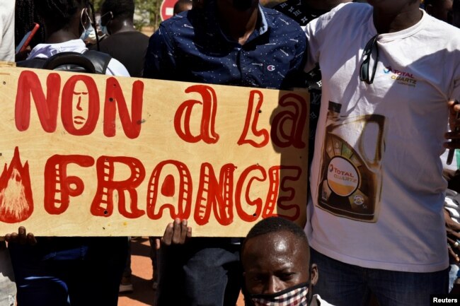 ARCHIVES - Des manifestants tiennent une pancarte sur laquelle on peut lire "Non à la France" lors d'une manifestation demandant le départ des forces françaises du Burkina Faso, dans la capitale Ouagadougou, le 16 novembre 2021.