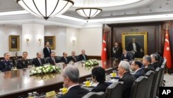 In this photo released by the Turkish Presidency Press Office, Turkish President Abdullah Gul (C) and Prime Minister Recep Tayyip Erdogan (7th L) during a meeting of the National Security Council in Ankara, Dec. 26, 2013. 