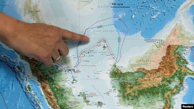 FILE - Indonesia's Deputy Minister for Maritime Affairs Arif Havas Oegroseno points at the location of North Natuna Sea on a new map of Indonesia during talks with reporters in Jakarta, Indonesia, July 14, 2017. REUTERS/Beawiharta/File Photo