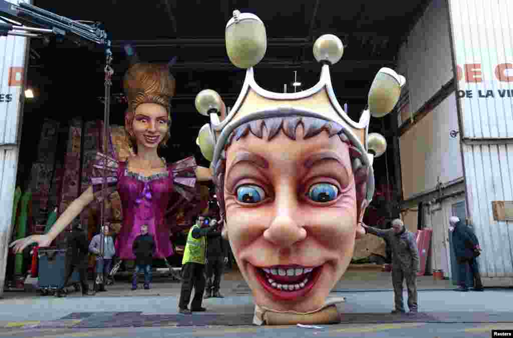 Workers hold a giant figure showing the King of Carnival during preparations for the carnival parade in Nice, France.