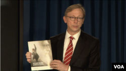 U.S. Special Representative for Iran Brian Hook speaks at a Sept. 28, 2018, press briefing in New York, holding a copy of the State Department's Sept. 25 report "Outlaw Regime: A Chronicle of Iran's Destructive Activities." 