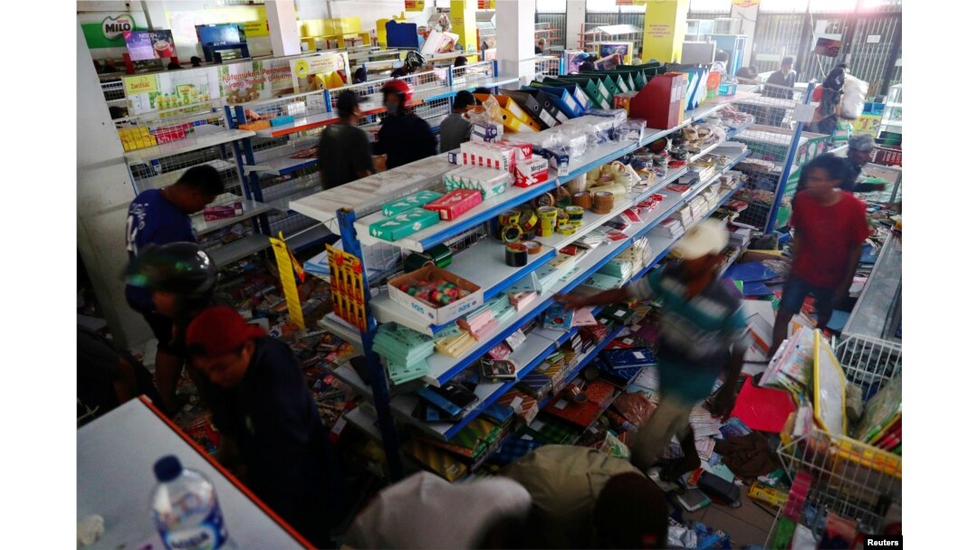 Para penyintas gempa dan tsunami mencari barang-barang di sebuah toko di Palu, Sulawesi Tengah, Selasa, 2 Oktober 2018.
