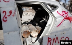 FILE - Bombs inside a vehicle used by the Islamic State militants in suicide car bombings are pictured after a demining team defused them in Raqqa, Syria, Oct. 18, 2017.