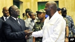 Ivorian President Laurent Gbagbo (R) speaks with Ivorian Defense minister Amani N'guessan (L) at presidential palace in Abidjan, 30 Nov 2009