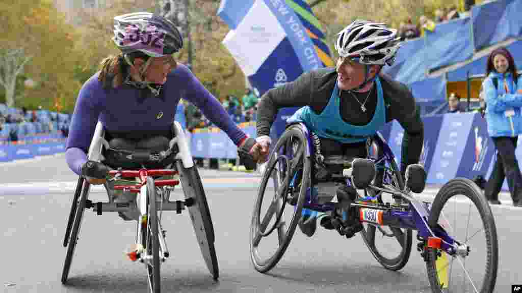 Manuela Schar de la Suisse, à gauche, félicite la championne, Tatyana McFadden des États-Unis. Les deux ont pris part à la course en fauteuil roulant, version dames, du 44eme marathon de New York à New York, le 2 novembre 2014. 