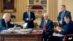 President Donald Trump accompanied by, from second from left, Chief of Staff Reince Priebus, Vice President Mike Pence, White House press secretary Sean Spicer and National Security Adviser Michael Flynn speaks on the phone with Russian President Vladimir