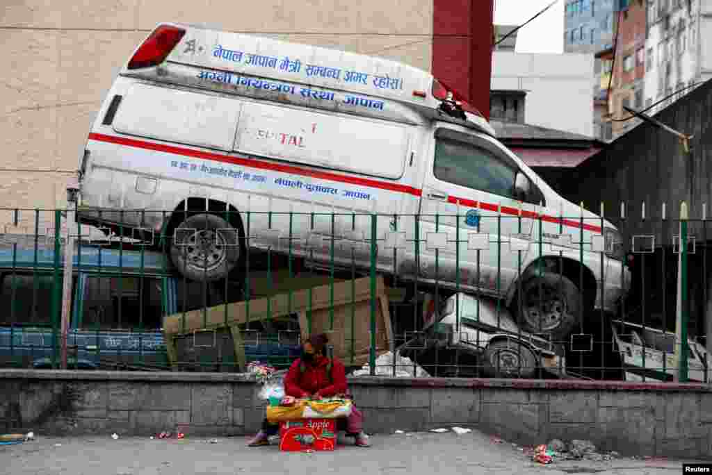 A street vendor sits out a hospital compound with an abandoned ambulance&nbsp;as the major second coronavirus wave surges in Kathmandu, Nepal.&nbsp; &nbsp;