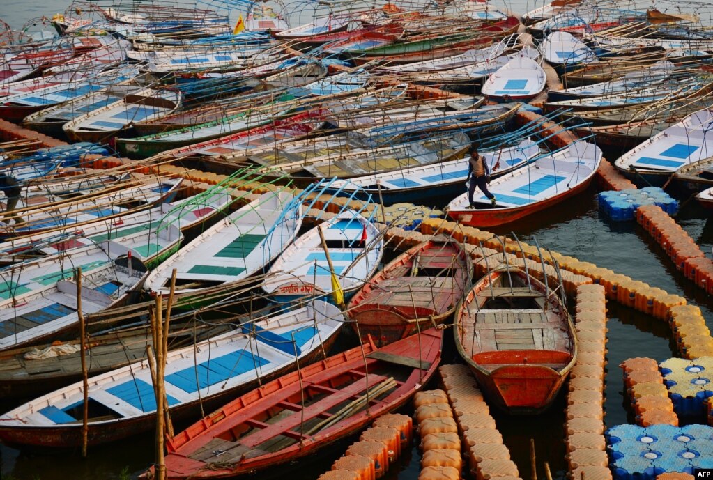 A boatman walks on a floating structure made of plastic near the banks of River Yamuna in Allahabad, India.