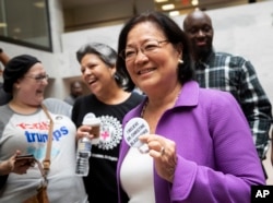 Sen. Mazie Hirono, D-Hawaii, a member of the Senate Judiciary Committee, is welcomed by protesters opposed to President Donald Trump's Supreme Court nominee, Brett Kavanaugh, as they demonstrate in the Hart Senate Office Building on Capitol Hill in Washington, Sept. 20, 2018.