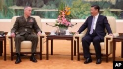 U.S. Chairman of the Joint Chiefs of Staff Gen. Joseph Dunford, left, chats with President Xi Jinping during a meeting at the Great Hall of the People in Beijing, Aug. 17, 2017. 