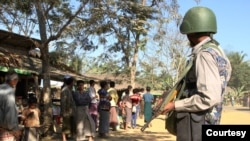 រូបឯកសារ៖ ប៉ូលិស​ការពារ​ព្រំដែន​មីយ៉ាន់ម៉ា​ម្នាក់ ឈរ​ក្បែរ​ក្រុម​ពលរដ្ឋ​រ៉ូហ៊ីងយ៉ា​កាន់សាសនា​អ៊ិស្លាម នៅ​មុខ​ផ្ទះ​របស់​ពួកគេ​ក្នុង​ភូមិ​មួយ​ដែល​ត្រូវ​បាន​គេ​ឃើញ​ក្នុង​ដំណើរ​ទស្សនកិច្ច​ដែល​រៀបចំ​ដោយ​រដ្ឋាភិបាល​សម្រាប់​អ្នកកាសែត​នៅក្នុង​រដ្ឋ Rakhine កាលពី​ថ្ងៃទី២៥ ខែមករា ឆ្នាំ២០១៩។