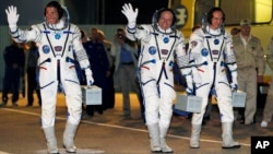 마이클 홉킨스(왼쪽) 올렉 코토프(가운데) 그리고 세르게이 랴잔스키 3우주인들이 25일 소유즈 우주선에 탑승하고있다. 