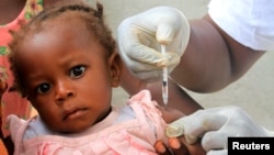 FILE - UNICEF team vaccinates children against polio at St. Ambrose church in Abidjan, Cote d'Ivoire, March 9, 2011.