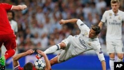 Cristiana Ronaldo de Real Madrid, au centre, et Xani Alonso, en position couchée, se battent pour la balle lors du match de quart de finale de la Ligue des champions au stade Santiago Bernabeu à Madrid, Espagne, 18 avril 2017.