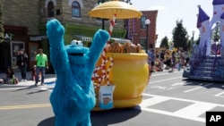 In this 2019 photo, Cookie Monster dances around his cookie jar at SeaWorld Orlando's opening of Sesame Street land in Orlando, Florida. (AP Photo/John Raoux)