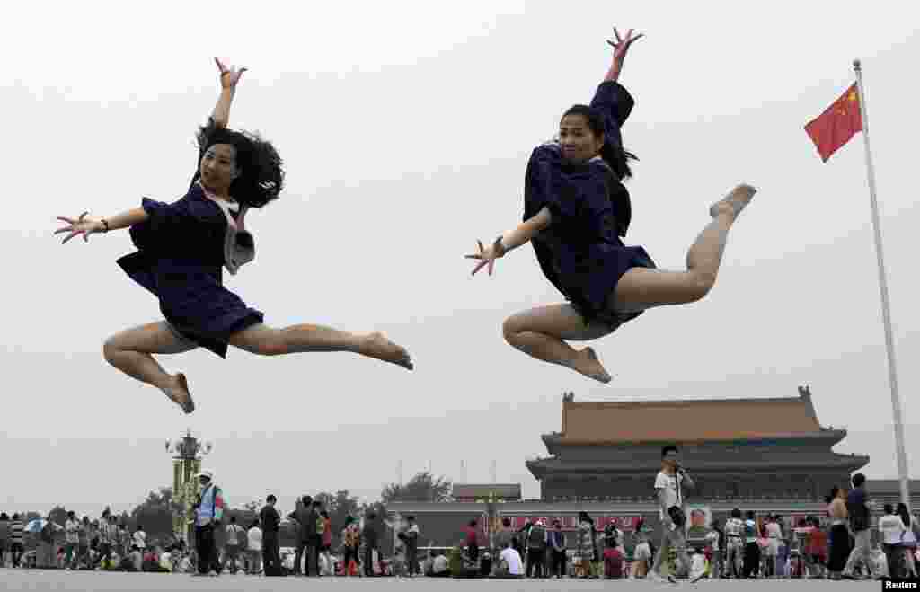 Graduates jump as they pose for photographs in front of the Tiananmen Gate and the giant portrait of late Chinese Chairman Mao Zedong, on the Tiananmen Square in Beijing, China, June 19, 2014.