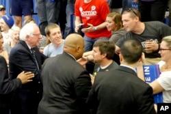 Democratic presidential candidate Vermont Senator Bernie Sanders, left, greets supporters as he leaves a campaign rally at Fitzgerald Fieldhouse on the University of Pittsburgh campus, in Pittsburgh, April 26, 2016.