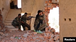 FILE - Kurdish People's Protection Units (YPG) fighters take up positions inside a damaged building in al-Vilat al-Homor neighborhood in Hasaka city, as they monitor the movements of Islamic State fighters.