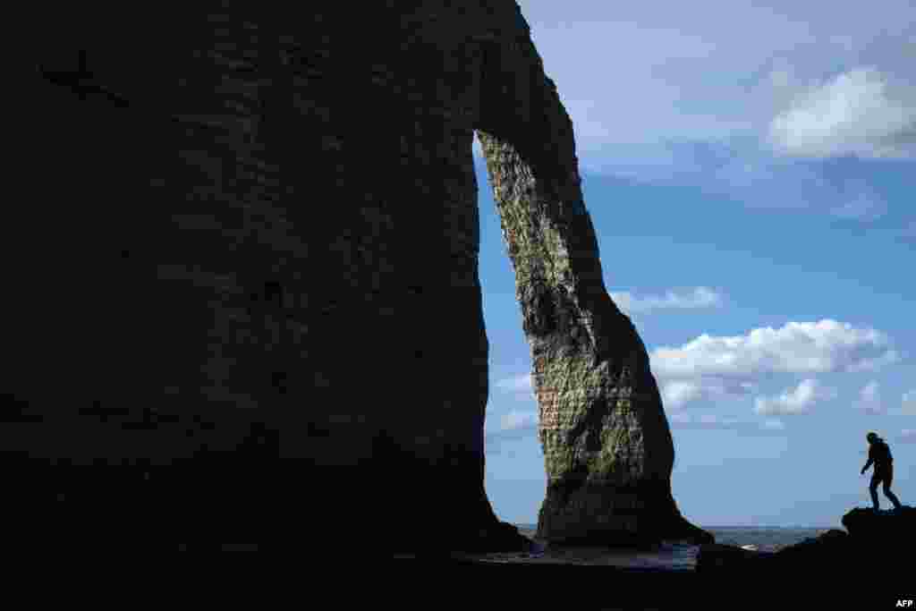 People walk on the cliff of Etretat, northwestern France.