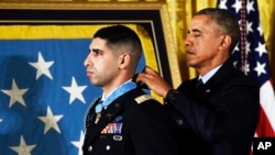 오바마 대통령이 아프가니스탄에서 전공을 세우고 퇴역한 플로렌트 그로버그 육군 대위에게 12일 백악관에서 명예훈장을 수여하고 있다.