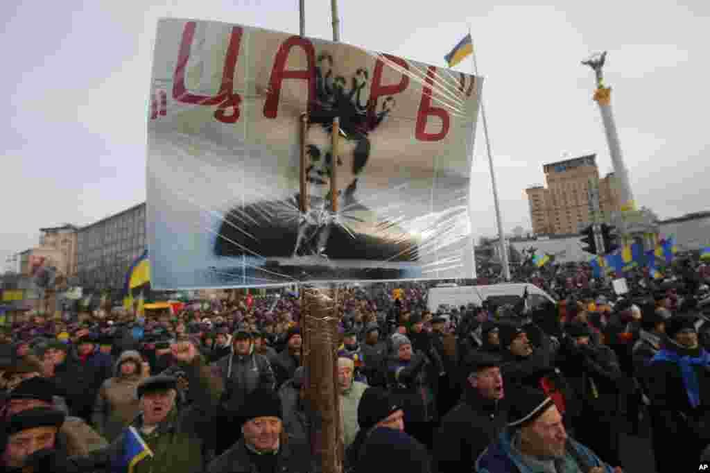 Protesters hold a poster with a portrait of President Viktor Yanukovych that reads "tsar" as they rally in Independence Square in Kyiv, Dec. 3, 2013.