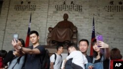 中国大陆观光客2019年4月4日在台北中正纪念堂里拍照留念。