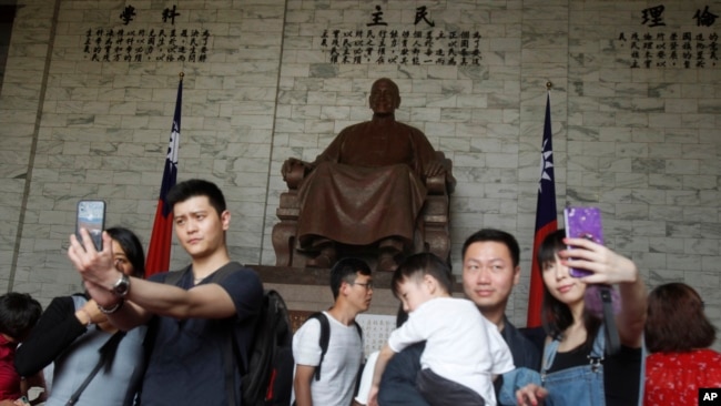 中国大陆观光客2019年4月4日在台北中正纪念堂里拍照留念。